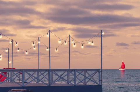 Romantic pier at sunset with lanterns Stock Photos