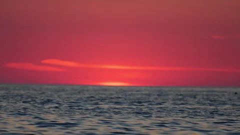 Romantic pink and red sunset over the sea with gentle waves, 4K slow motion Stock Footage 334128764