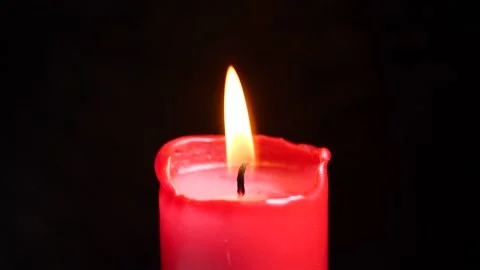 A romantic red candle burning isolated in front of a black background. Stock Footage 146221747