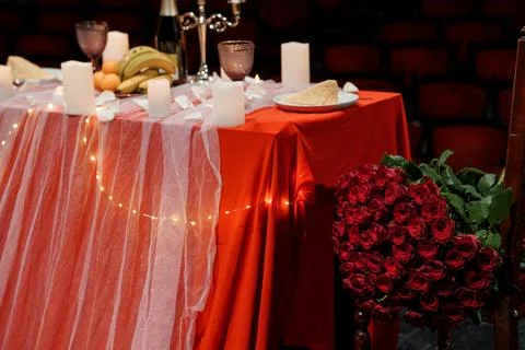 Romantic Red Table Setting with Rose Bouquet, Candles, and Fruit Arrangemen.. Stock Photos