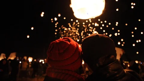 Romantic scene of a couple watching floating lanterns. Thousands of lanterns Stock Footage 99316467
