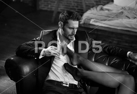 Romantic scene - elegant man and sensual young woman wearing sexy underwear Stock Photos