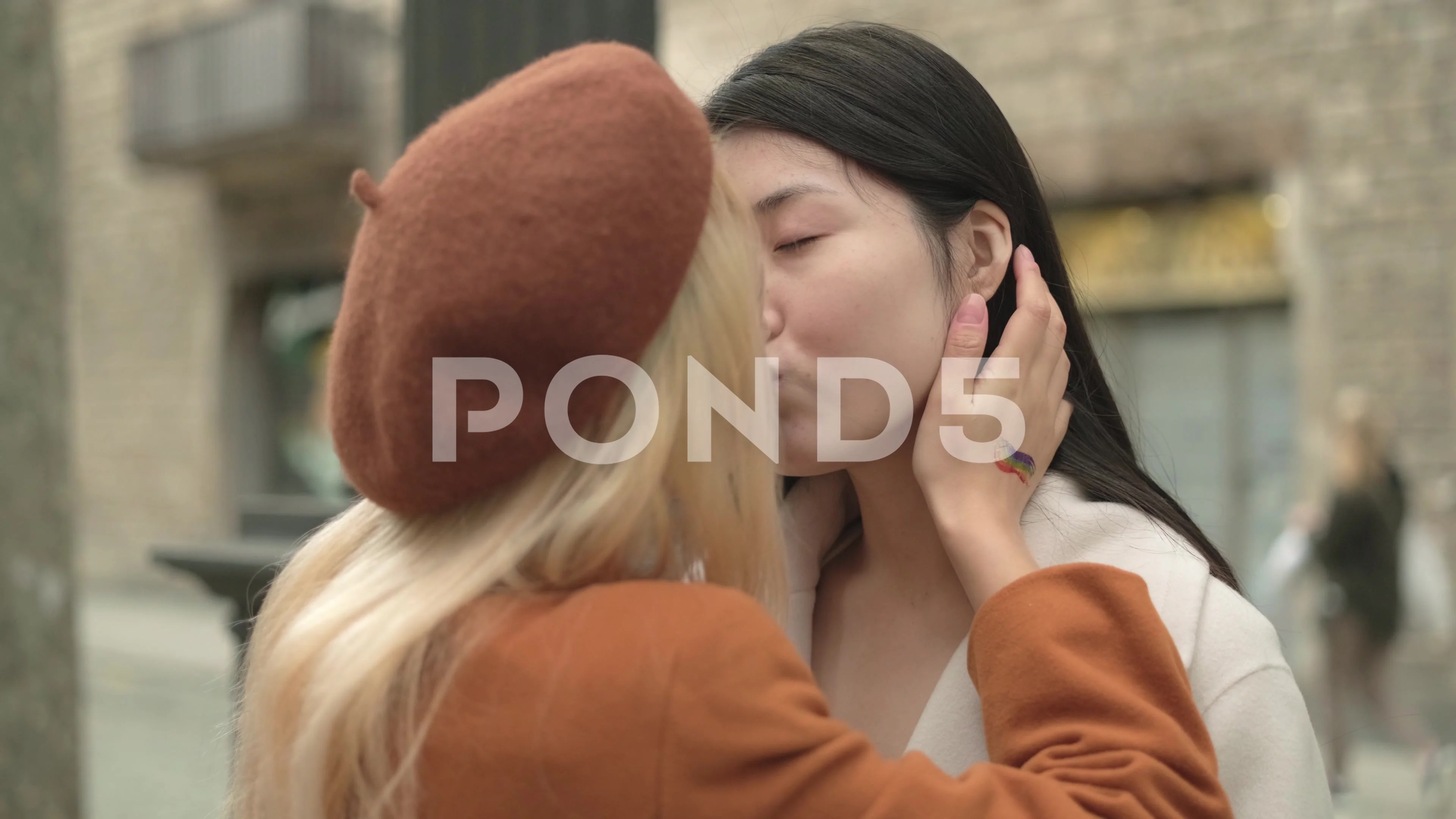 Romantic scene of a lesbian asian couple kissing outdoors