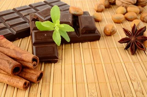 Romantic set of chocolate anise nuts cinnamon with leaves of sage on wooden m Stock Photos