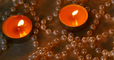 Romantic setting lit candles and pearl beads Stock Footage 142554400