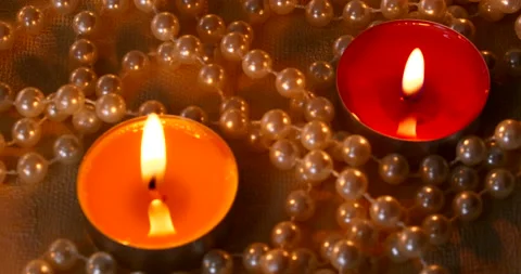 Romantic setting lit candles and pearl beads Stock Footage 142554907