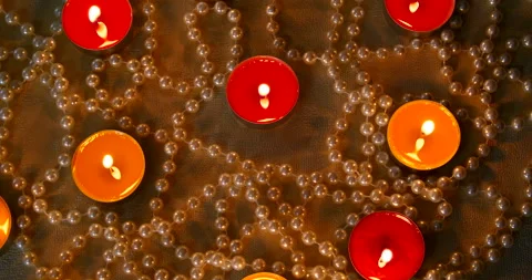 Romantic setting lit candles and pearl beads Stock Footage 142555835