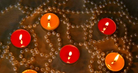 Romantic setting lit candles and pearl beads Stock Footage 142561749