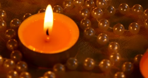 Romantic setting lit candles and pearl beads Stock Footage 142575130