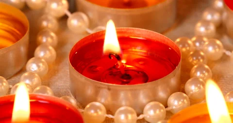 Romantic setting lit candles and pearl beads Stock Footage 142721944