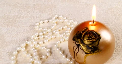 Romantic setting lit candles and pearl beads Stock Footage 142724813