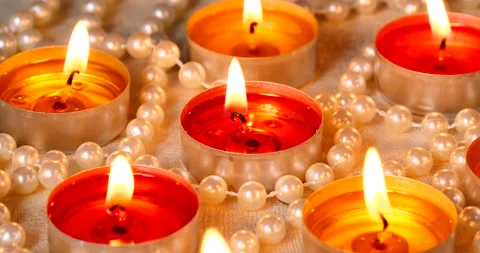 Romantic setting lit candles and pearl beads Stock Footage 142809089