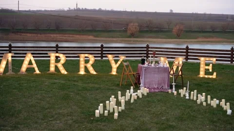 The romantic setting of a marriage proposal, a table decorated with flowers Stock Footage 155935477