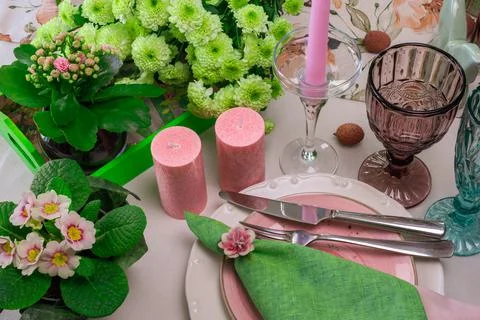 Romantic spring table setting for two with wine glasses, candles and flowers Stock Photos