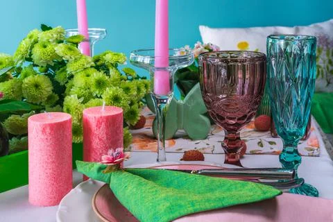Romantic spring table setting for two with wine glasses, candles and flowers Stock Photos