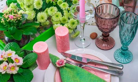Romantic spring table setting for two with wine glasses, candles and flowers Stock Photos
