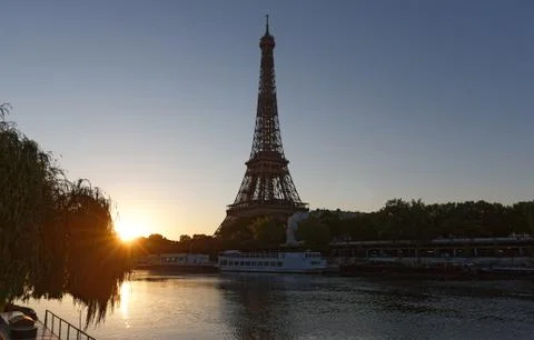 Romantic sunrise background. Eiffel Tower with boats on Seine river in Paris Stock Photos