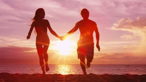 Romantic sunset beach couple holding hands on beach running having fun on travel Stock Footage