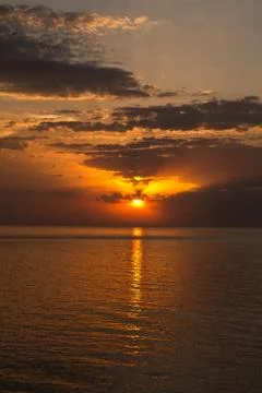 Romantic sunset at the beach. Direct view to the horizont with water and cl.. Stock-Fotos