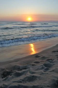 Romantic sunset reflected on the beach, vertical Stock Photos