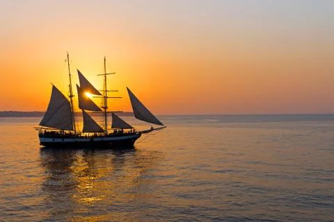 Romantic sunset with sailing ship Stock Photos