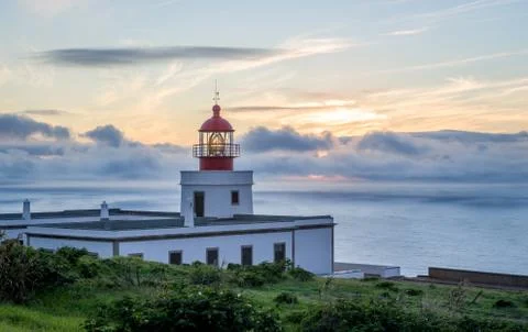 Romantic sunset view of lighted lightouse Stock Photos