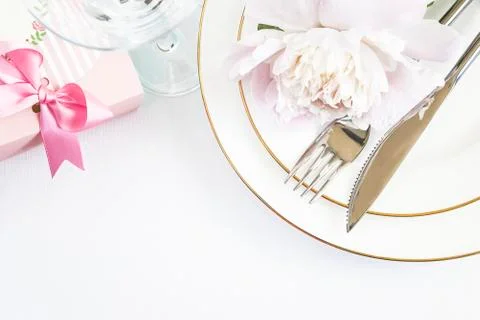 Romantic table setting with pink gift box and peony. Copy space, flat lay Stock Photos