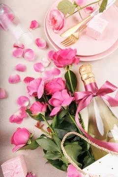 Romantic table setting with pink roses and champagne bottle Foto stock