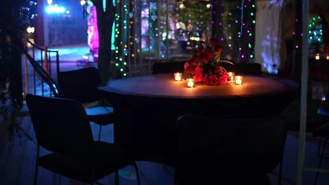 Romantic table setup with red roses and glowing candle lights Vídeo Stock 335270758