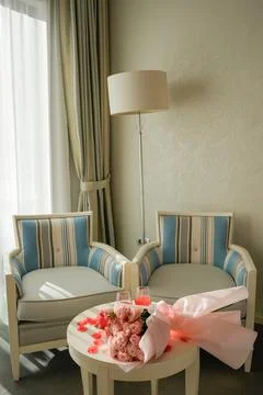 Romantic Table Setup with Roses, Drinks and Desserts in Cozy Room Stock Photos