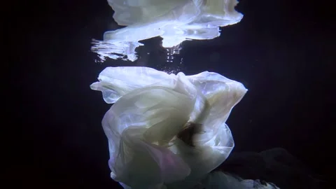 Romantic underwater slow motion shot, floating woman in dark deepness Stock-Footage 167494635