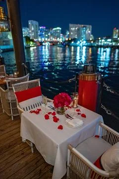 Romantic Valentine's Day table setting on water with city skyline Stock Photos