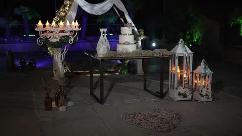 Romantic wedding cake table with glowing lanterns at night Stock Footage 317377857