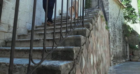 Romantic wedding couple going down the stairs in old town in Montenegro Stock Footage 137906344