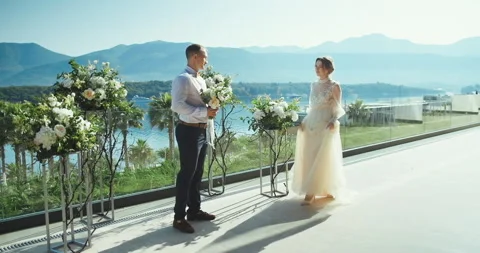 Romantic wedding couple looking to each other and smiling holding hands Stock Footage 148411051