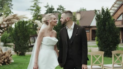 Romantic wedding scene with a couple, bride and groom walking holding hands Video stock 322051671