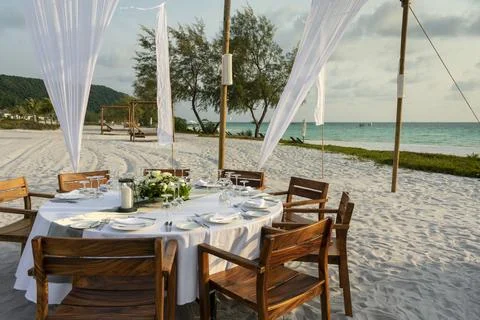 Romantic wedding table design at sunset outside on asian beach Stock Photos