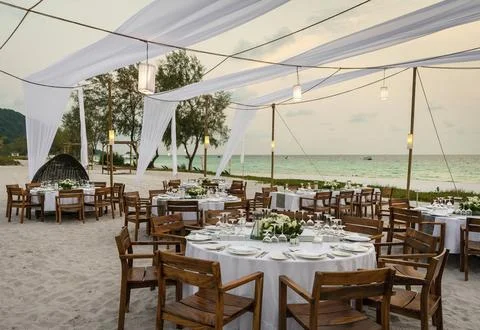 Romantic wedding table design at sunset outside on asian beach Stock Photos