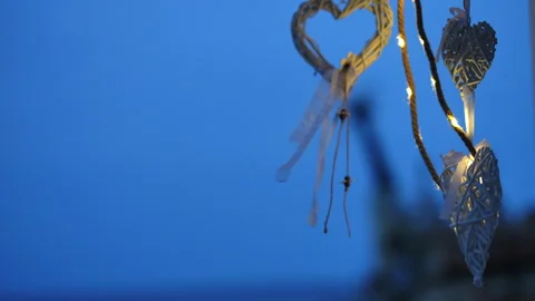 Romantic wicker hearts decorations hanging at twilight Vídeos de archivo 340339784
