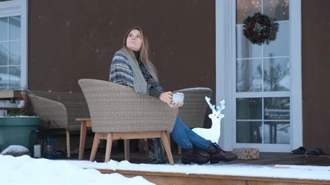 Romantic woman drinking coffee while sitting on the terrace in winter Stock Footage 157181921