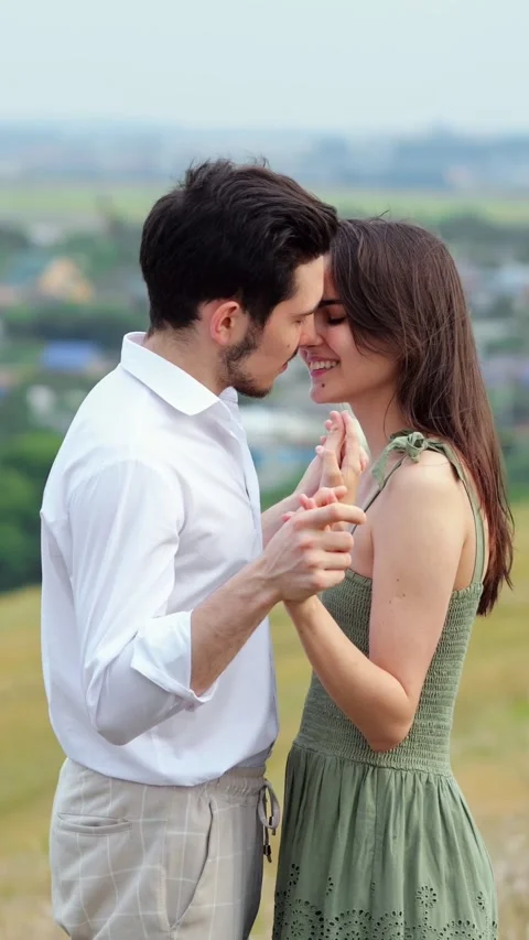 Romantic young couple dancing and smiling while holding hands in a field Stock Footage 341443894