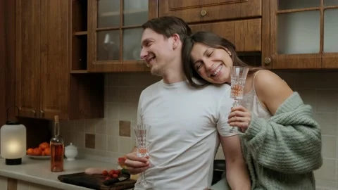 Romantic young couple that enjoys a glass of wine and relaxing in kitchen. Stock Footage 148657953