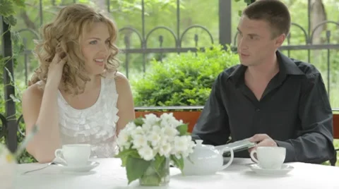 Romantic young couple looking through menu outdoors  in summer cafe Stock-Footage 7766858