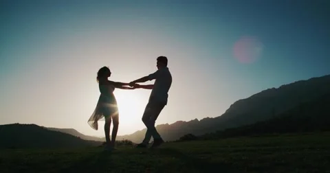 Romantic young couple silhouette. woman and man holding hand in circle together Stock Footage