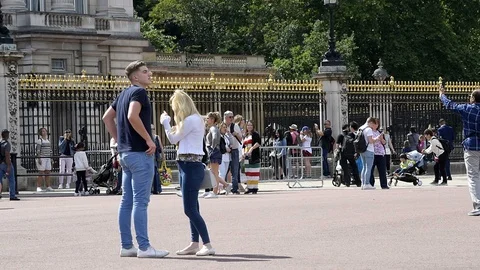 Romantic young couple standing in front of Buckingham Palace Stock Footage 96715468
