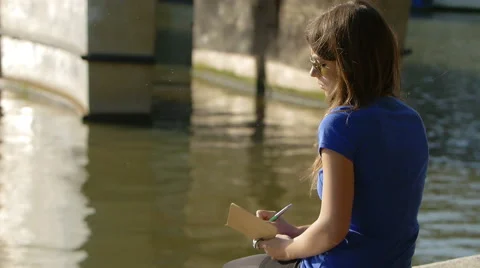 Romantic young woman writing close the river Stock Footage 57096653