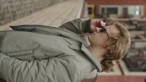Rome, 10 May 2023: Vertical video. Young curly-haired man with model sunglasses Video stock 316320660