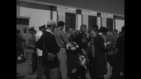 ROME - 1960: Scoreboard wall - Crowd studies posted competition results Stock Footage 344501994