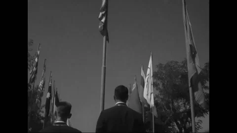 ROME - 1960: Team representative - Blazer-clad member poses beneath flag strings 库存影片 344501966