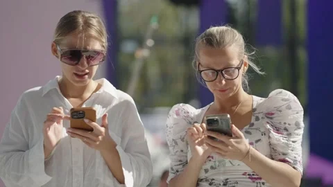 Rome , 20 May 2023: Two young girls with glasses scrolling on their smartphone 스톡 동영상 312274784